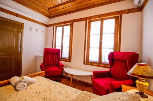 a room with two red chairs and a table at Hotel Bebej Tradicional in Gjirokastër