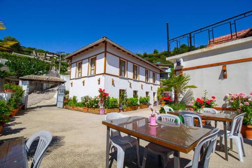 a patio with tables and chairs and a building at Hotel Bebej Tradicional in Gjirokastër