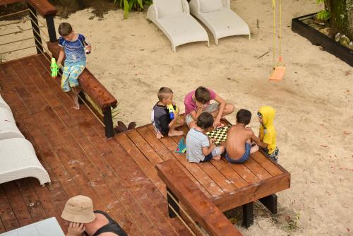 a group of children sitting on a wooden bench at B's Beach House on Muri Lagoon in Rarotonga