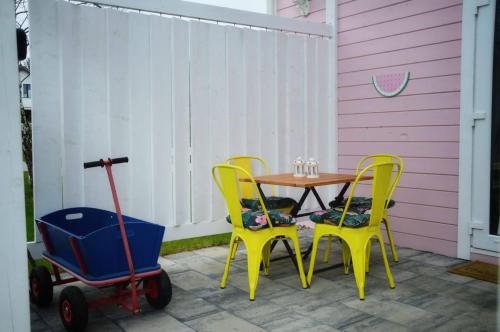 a table and two chairs and a cart on a patio at Bajkowy domek Villa Rosa na Kaszubach in Grzybowo