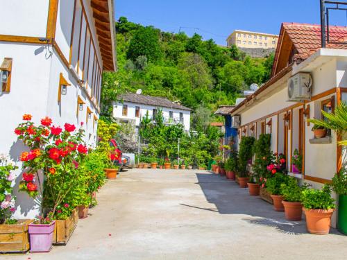 a street in a town with flowers in pots at Hotel Bebej Tradicional in Gjirokastër