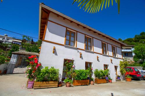 a white building with potted plants in front of it at Hotel Bebej Tradicional in Gjirokastër