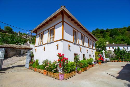 a house with flowers and plants in front of it at Hotel Bebej Tradicional in Gjirokastër