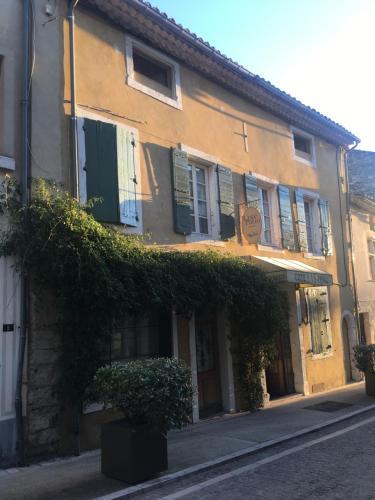 a building with ivy on the side of a street at LE PATIO in Grignan