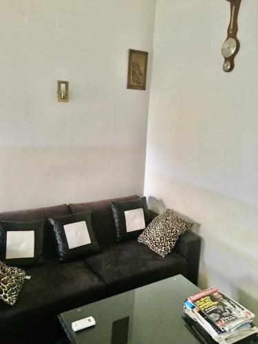 a living room with a black couch and a table at Résidence ARCHANGE in Pointe-Noire