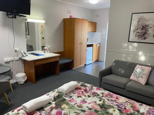 a living room with a bed and a couch at Camperdown Cascade Motel in Camperdown