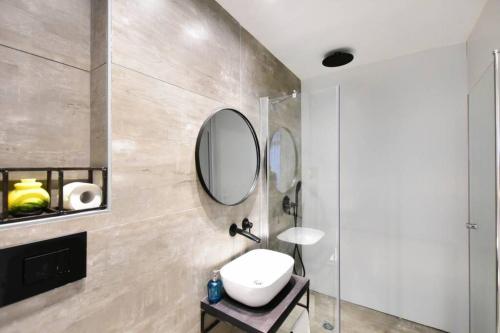 a bathroom with a sink and a mirror at Jerusalem of concrete&stell in Jerusalem