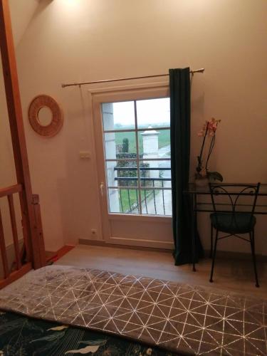 - une chambre avec une fenêtre, un lit et une chaise dans l'établissement Le clos des augers. Chambre Descartes, à Azay-sur-Cher