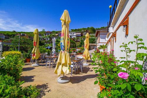 a group of yellow umbrellas and tables and chairs at Hotel Bebej Tradicional in Gjirokastër