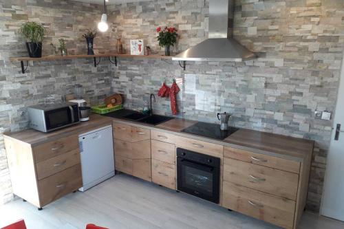 une cuisine avec un évier et une cuisinière four supérieur dans l'établissement Grand appartement avec jardin Promos en juillet location a la semaine samedi au samedi ou dimanche au dimanche, à Soulac-sur-Mer