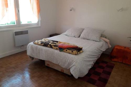 - une chambre avec un lit doté d'une couette et d'oreillers dans l'établissement Grand appartement avec jardin Promos en juillet location a la semaine samedi au samedi ou dimanche au dimanche, à Soulac-sur-Mer
