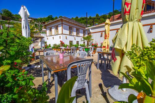 a patio with a table and chairs and an umbrella at Hotel Bebej Tradicional in Gjirokastër