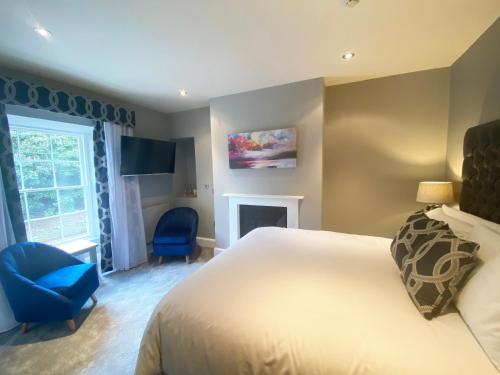 a bedroom with a white bed and a blue chair at Aberdunant Hall in Porthmadog