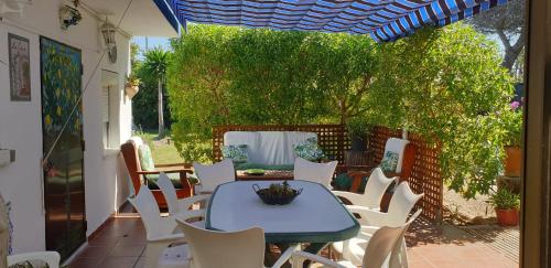 una mesa azul y sillas blancas en el patio en Finca Las Dunas con dos Chalets con jacuzzis en primera linea de playa uno de 4 dormitorios y otro de 2 dormitorios, en Rota