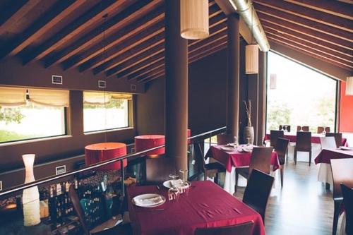 Teo的住宿－PARADA DE FRANCOS，餐厅设有红色的桌椅和窗户。