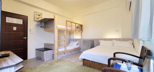 Habitación pequeña con cama, escalera y dormitorio. en Knight Inn, en Taitung