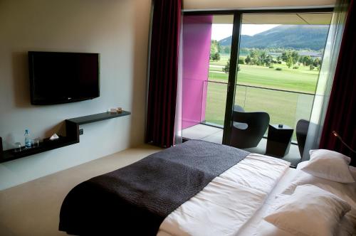 a hotel room with a bed and a large window at Miura Hotel in Čeladná