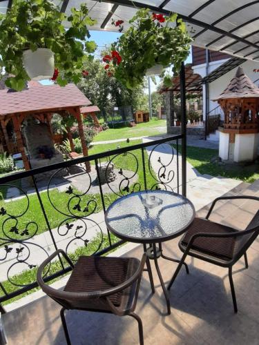 a patio with a table and chairs on a balcony at Pensiunea Casa Ancuta in Vadu Izei