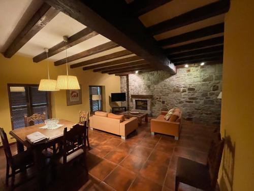 a living room with a table and a stone wall at La Borda del Tío Nicolás - Selva de Irati in Aribe
