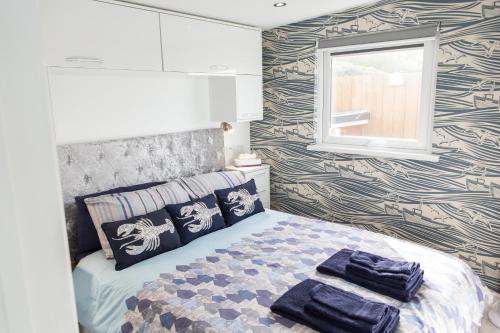 1 dormitorio con 1 cama con 2 toallas en Tony's Place with a breakwater view, en Plymouth