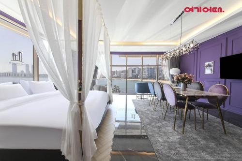 a hotel room with a bed and a table and chairs at De Homme Hotel in Busan