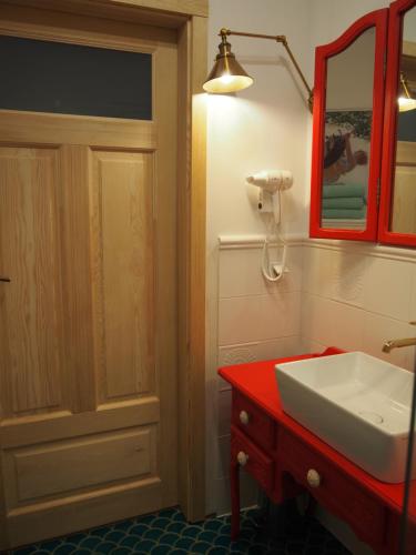 a bathroom with a white sink and a red cabinet at Apartament Wakacje i rowery gratis in Ostróda