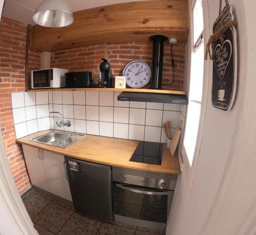 a small kitchen with a clock on the wall at Casa Olivera- apartament al Passeig Font Vella in Sant Hilari Sacalm