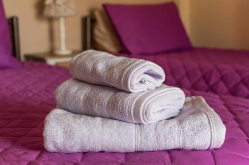 a stack of towels stacked on a bed at Spiti Anna Maria in Corfu