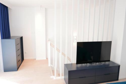 a living room with a flat screen tv on a black cabinet at Apartamenty Marco Polo in Dziwnówek