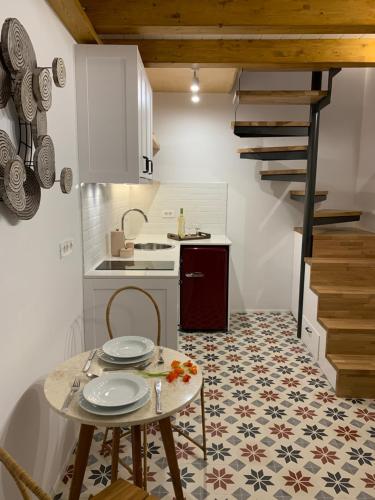 a kitchen with a table and a sink and a staircase at Casa Livieres in Chania Town