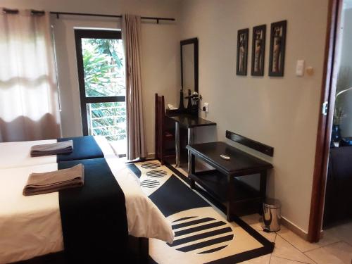 a bedroom with a bed and a desk and a window at Forest Lodge in St Lucia