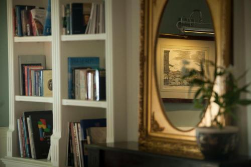 a room with a mirror and a table with books at Hotel Riviera & Maximilian's in Trieste