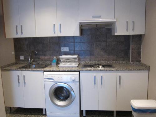 a kitchen with a washing machine and a sink at Apartamentos Abastos in Valencia