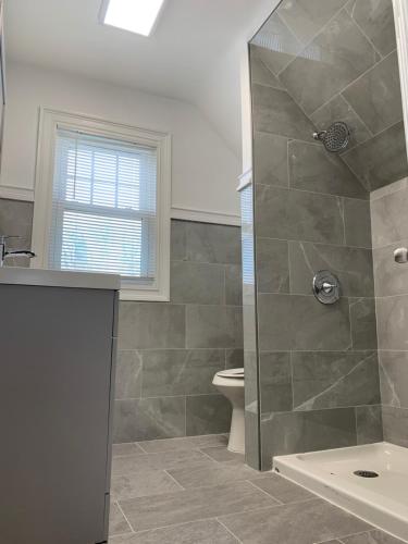 een badkamer met een douche en een toilet bij The Oakwood Cottage- With Private Yard & Parking, Minutes From Falls & Casino by Niagara Hospitality in Niagara Falls