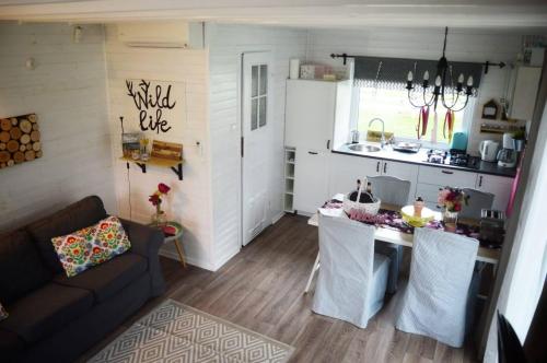 a kitchen and living room with a couch and a table at Bajkowy domek Villa Rosa na Kaszubach in Grzybowo