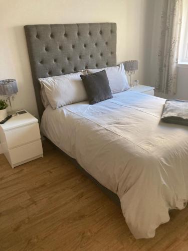 1 dormitorio con 1 cama grande y cabecero grande en Dunelm Snug en Seahouses