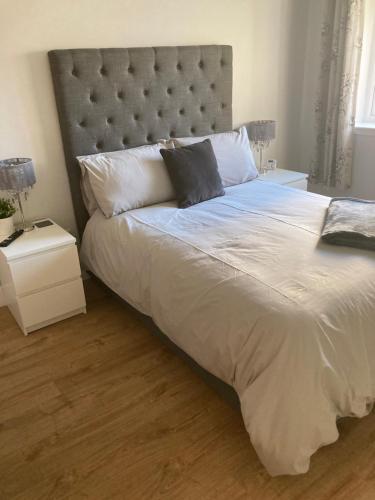 a bedroom with a large bed with a large headboard at Dunelm Snug in Seahouses