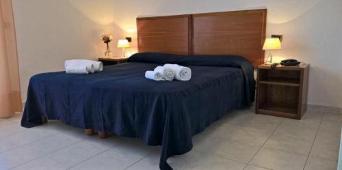 a hotel room with a bed with two towels on it at Hotel Riva Etrusca in Marina di Bibbona