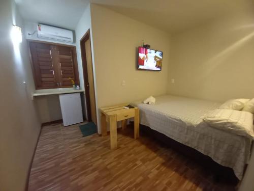 een kleine slaapkamer met een bed en een tafel bij Pousada A Casinha in Icaraí