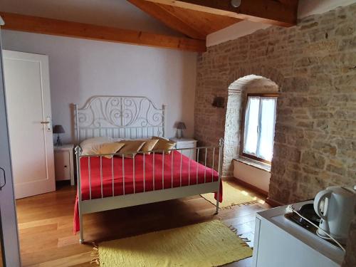 sypialnia z łóżkiem z czerwonym kocem w obiekcie Casa dei Boscarini w mieście Buje