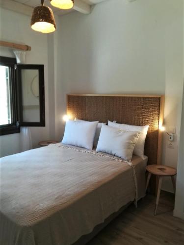 a bedroom with a large bed with white pillows at Almira Kalamos in Kálamos