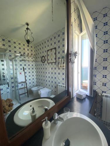 ein Badezimmer mit einer Badewanne und einem großen Spiegel in der Unterkunft Summer Paradise in Procida