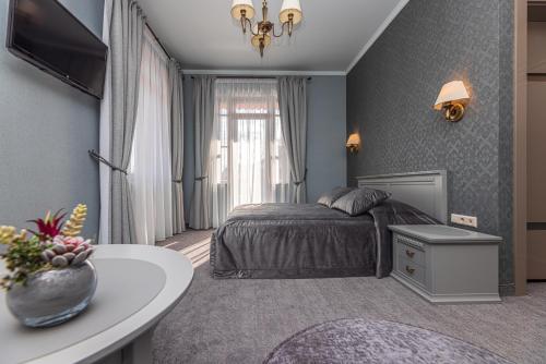 sypialnia z łóżkiem i stołem w pokoju w obiekcie Senoji Hansa Hotel w Połądze