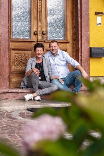 a man and a woman sitting in front of a door at GIRLINGGUT Schlafen Starten Salzburg in Elixhausen