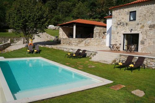 a swimming pool in the yard of a house at Quinta da Enxurreira in Ponte de Lima