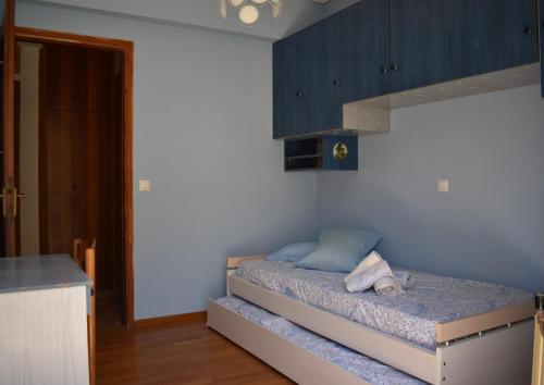 a bedroom with a bed with a blue wall at Dia's Holiday Home in Athens