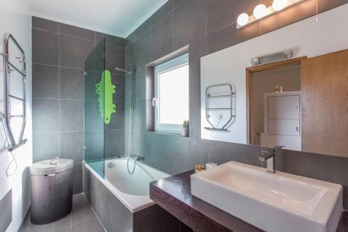 y baño con bañera, lavamanos y bañera. en Design Guincho Villa, en Cascais