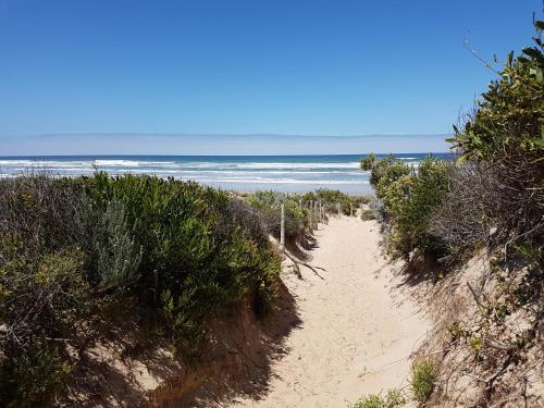 a sandy path leading to the ocean on a beach at Great Ness Beach House - 8 Person Spa - Pet-Friendly - Netflix - Linen included in Goolwa South