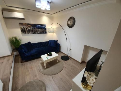 sala de estar con sofá azul y mesa en Apartment My Home, en Belgrado