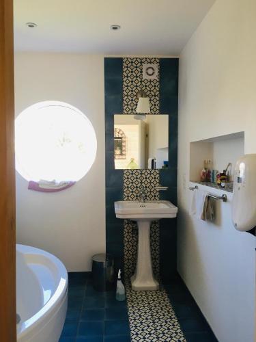 une salle de bain avec un lavabo et une baignoire dans l'établissement Au bercail de Bizebarre - Maison bois & pierre dans un hameau - Spa, à Saint-Vivien